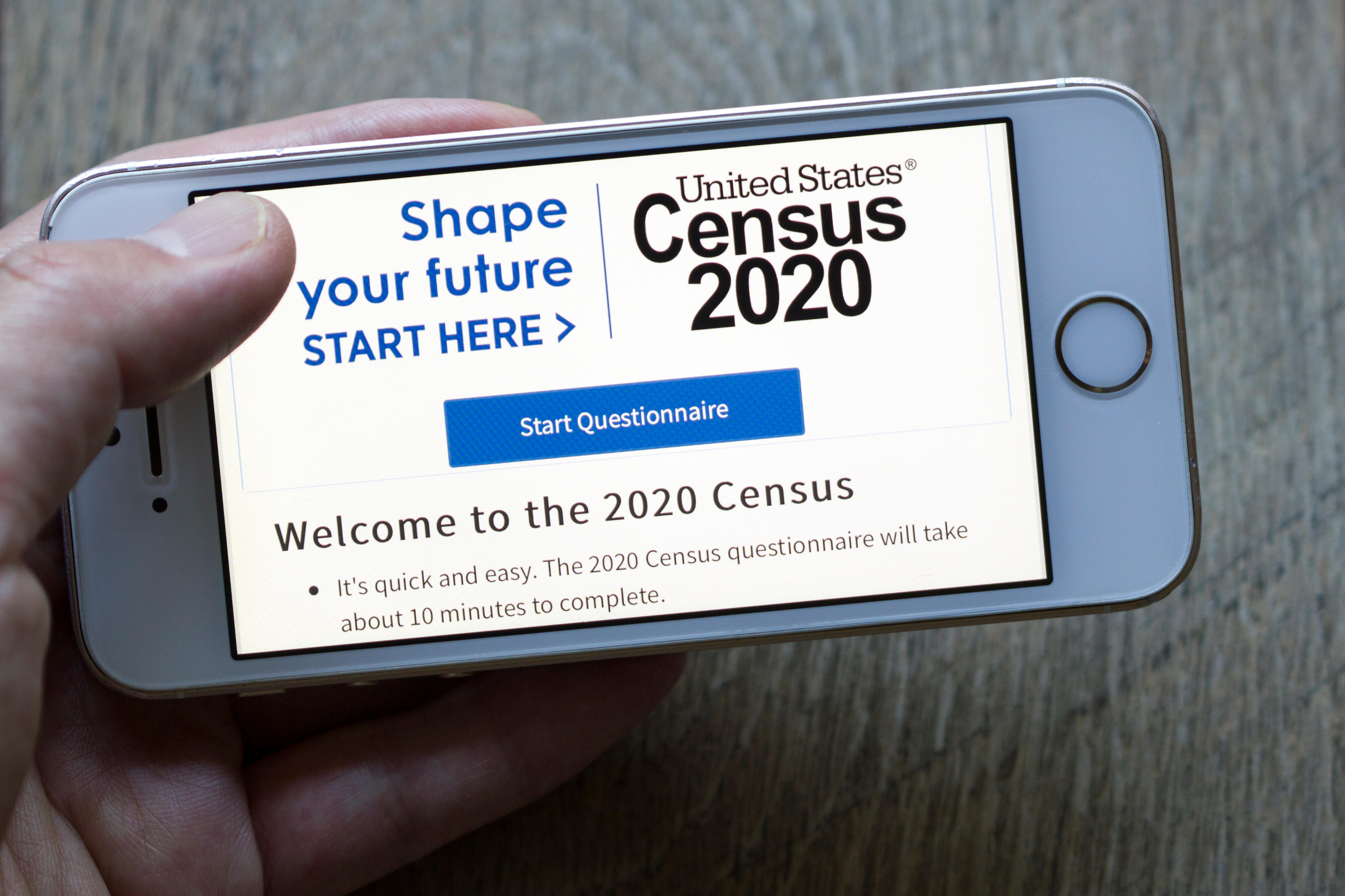 hand holding a smartphone with census page showing