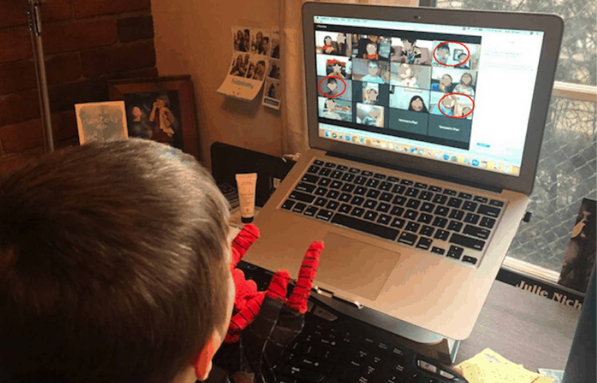 boy looking at screen with several faces and some obscured