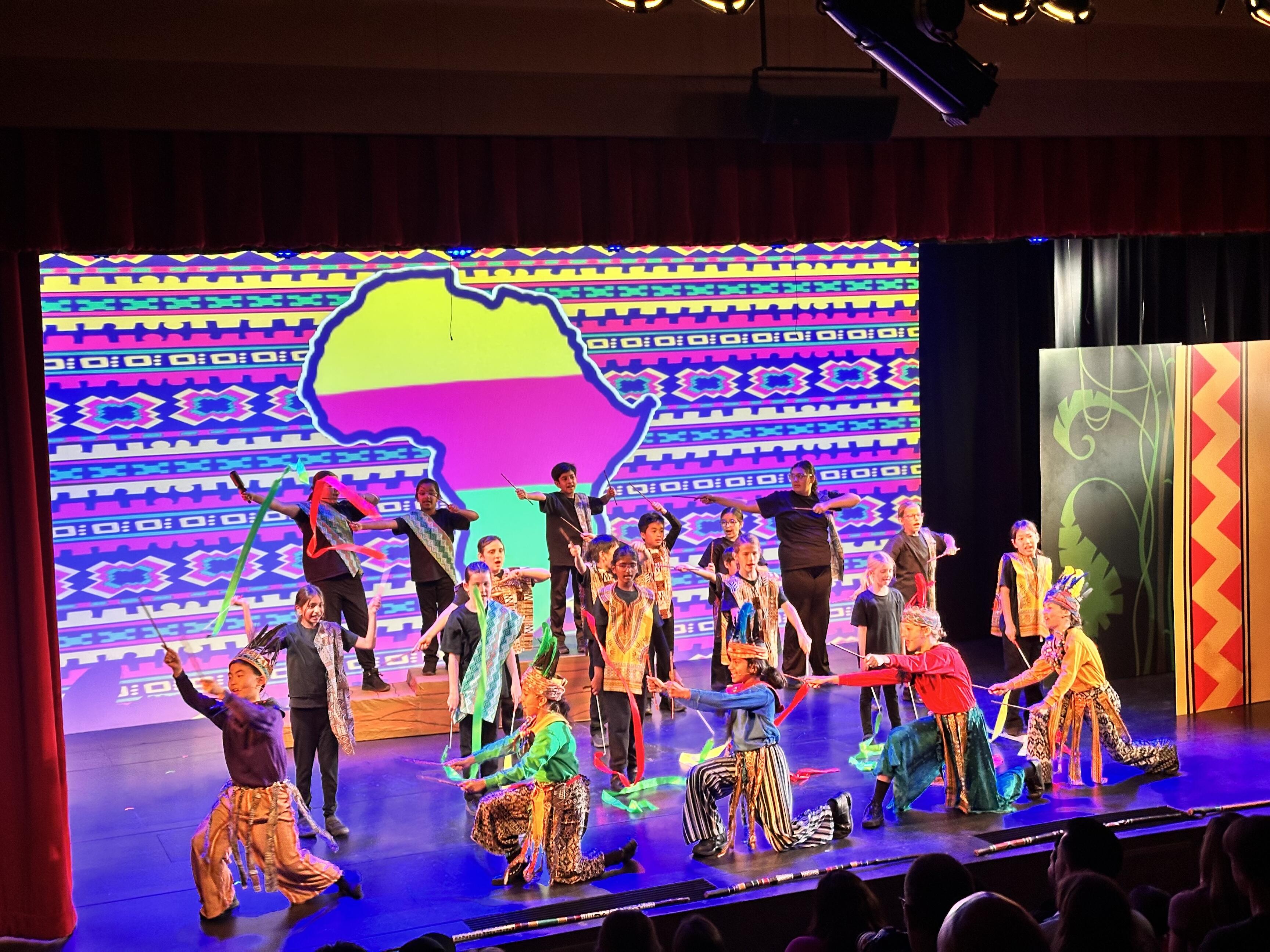 stage full of young students performing Lion King Jr.