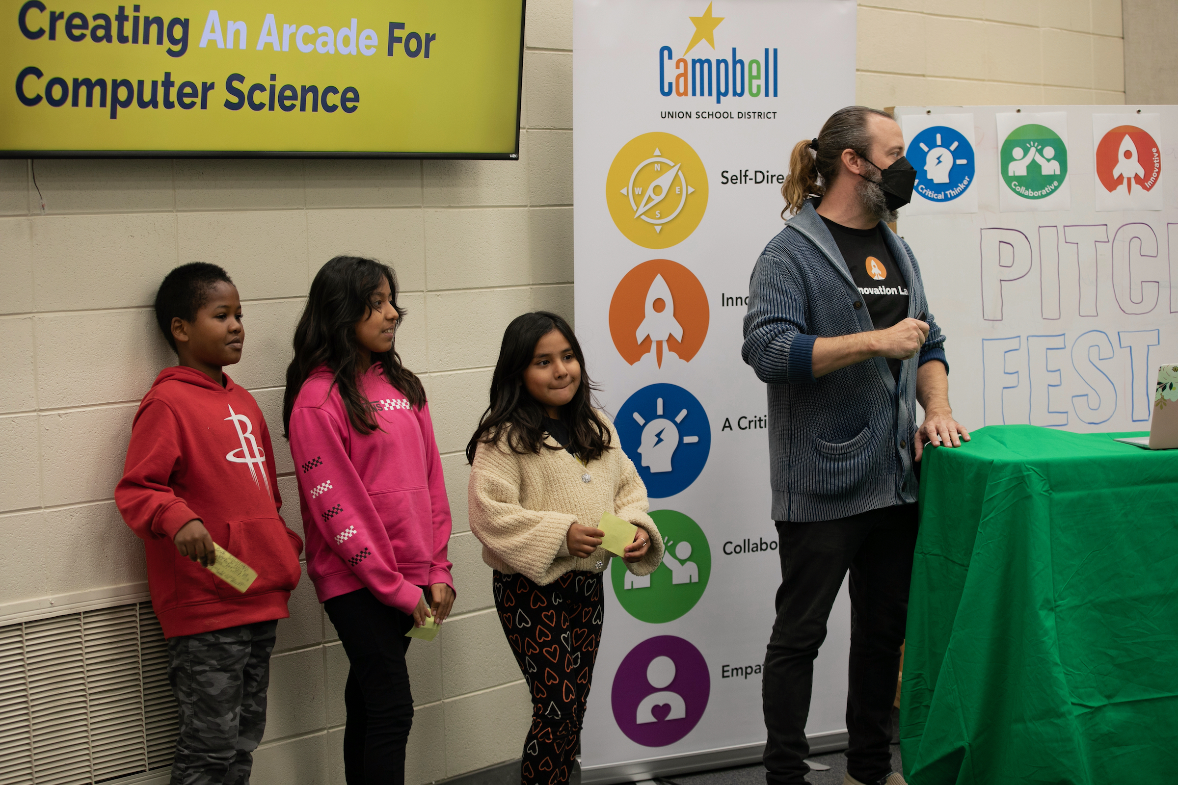 students and teacher standing and presenting to audience