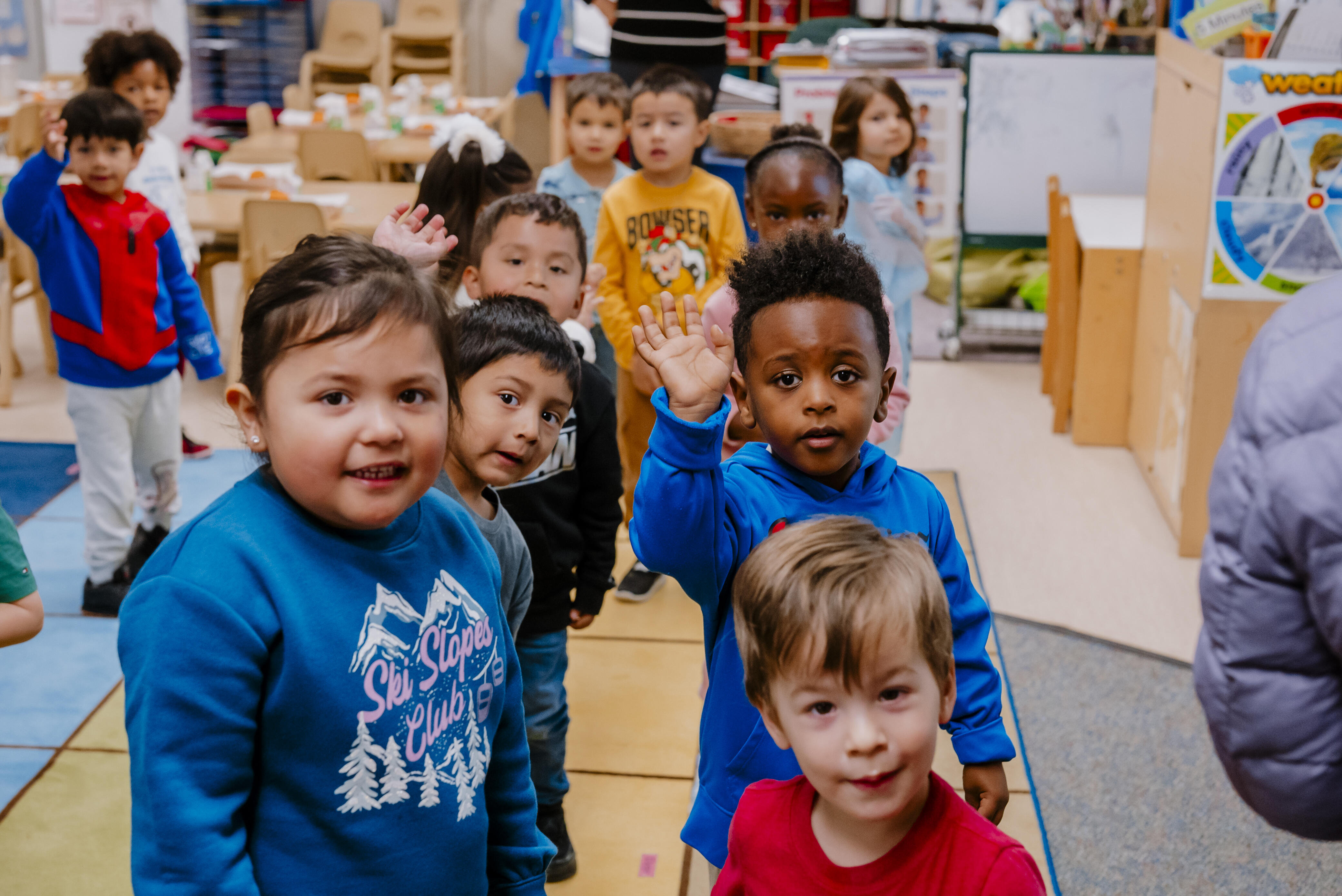 Preschool students at the Family Learning Center wave for the camera