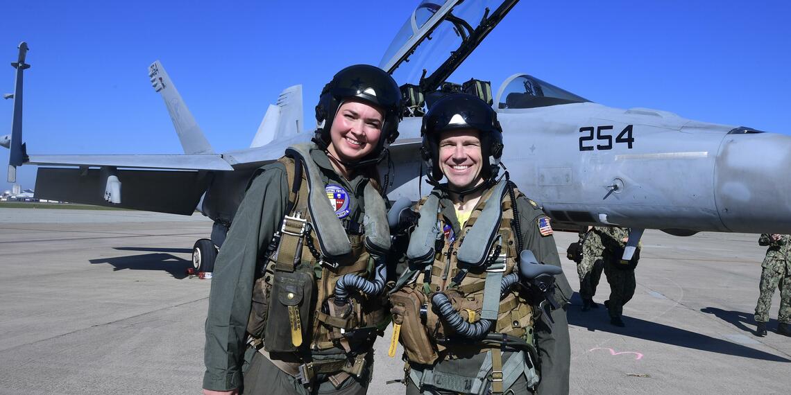 Castlemont teacher, Hailey Robinson, and the Navy pilot she flew with in the F-18 (pictured behind them).