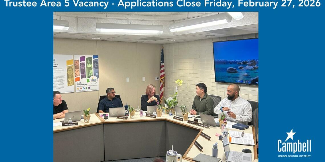 Photo of board members interacting with one another during a board meeting.