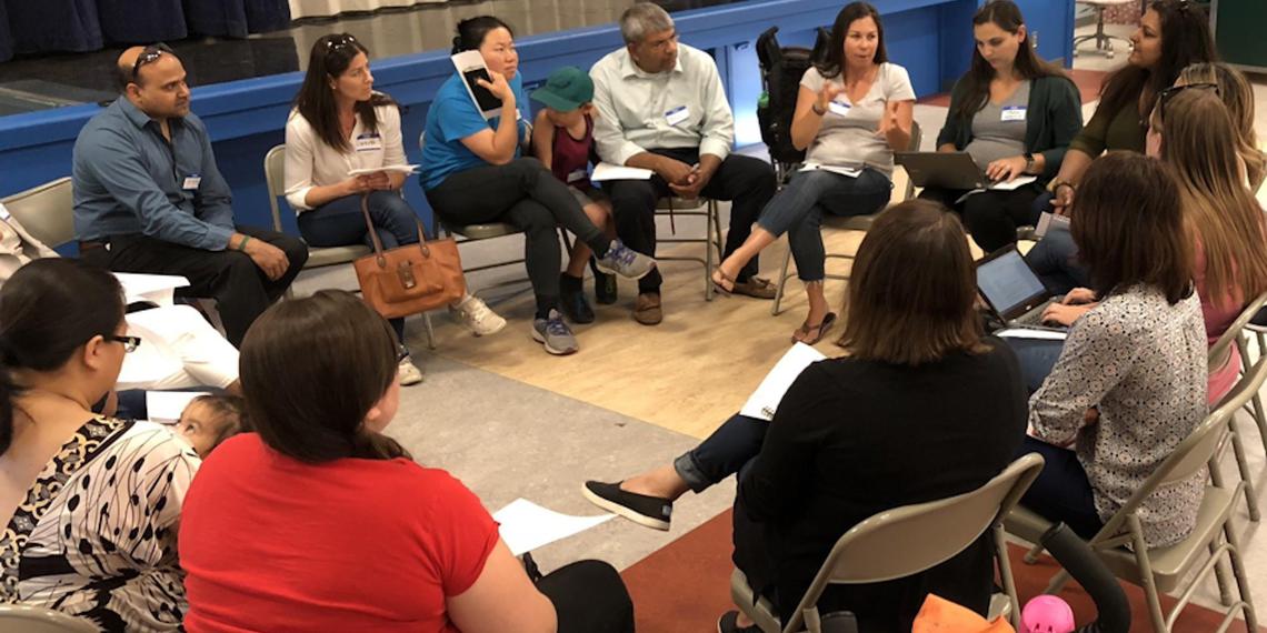 adults sitting in a circle engaged in discussion