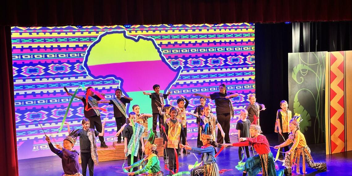 stage full of young students performing Lion King Jr.