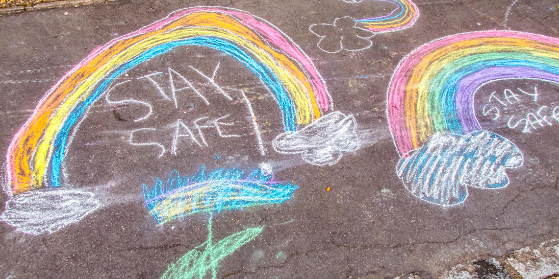 stay safe and chalk rainbows drawn on sidewalk