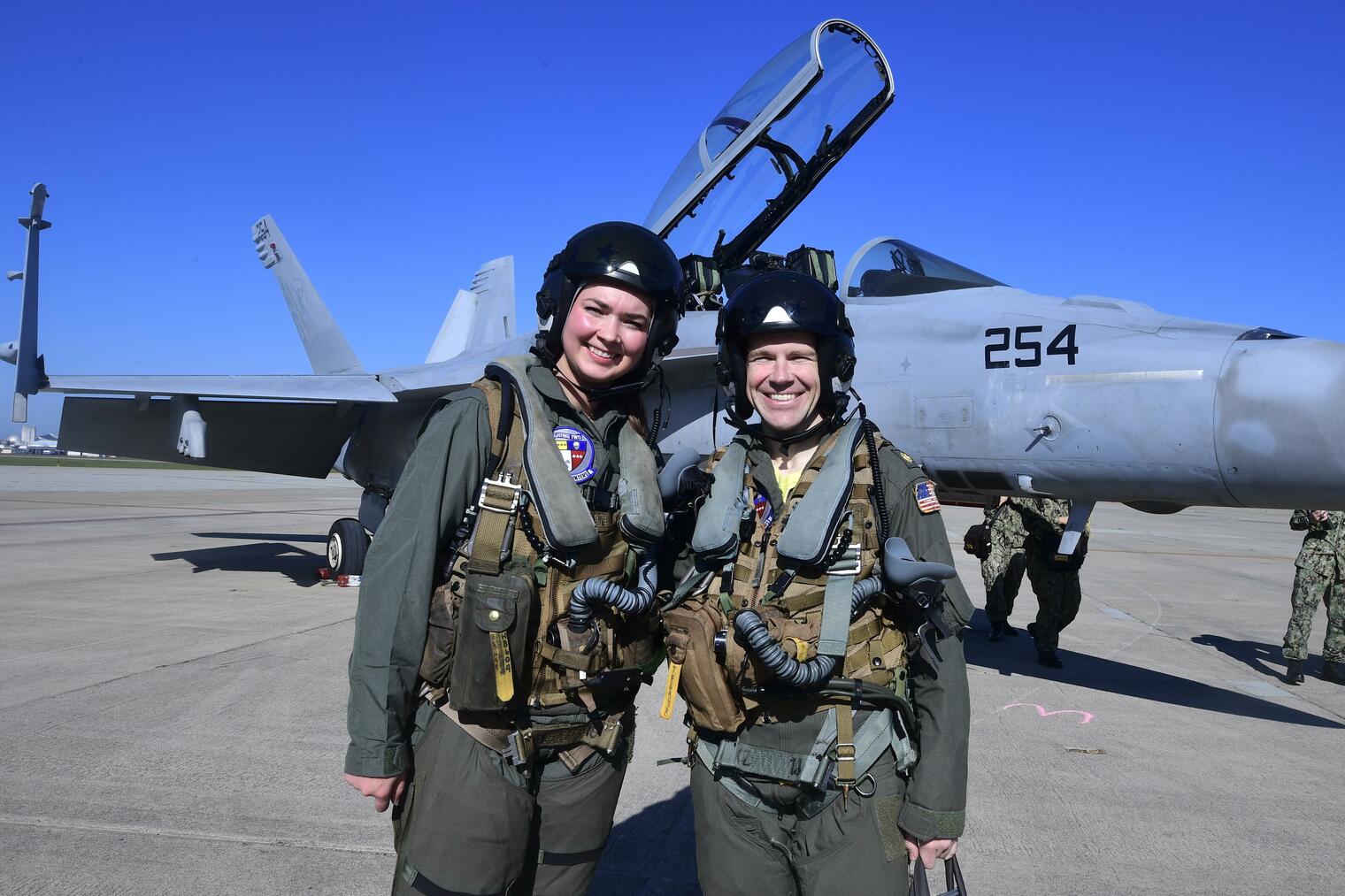 Castlemont teacher, Hailey Robinson, and the Navy pilot she flew with in the F-18 (pictured behind them).