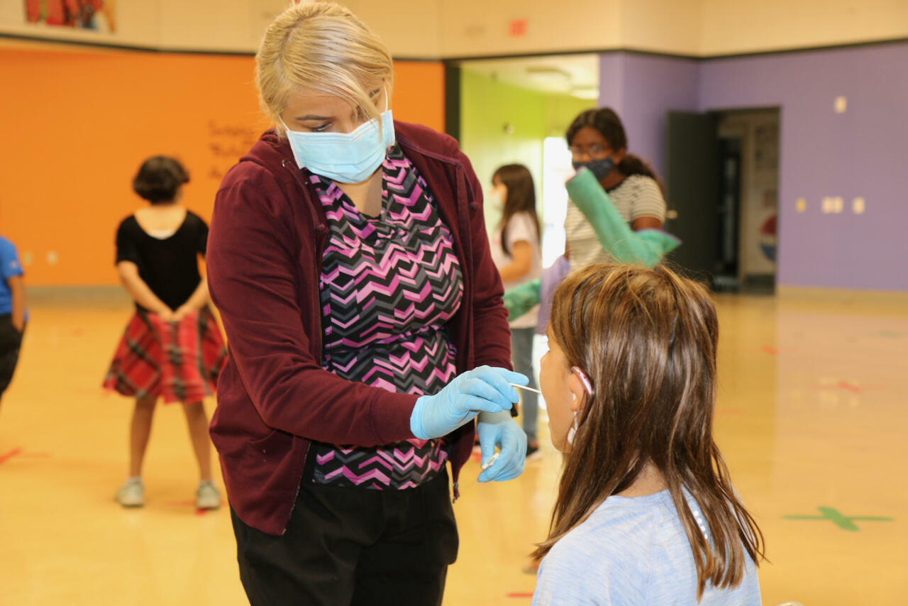 woman testing a child for covid
