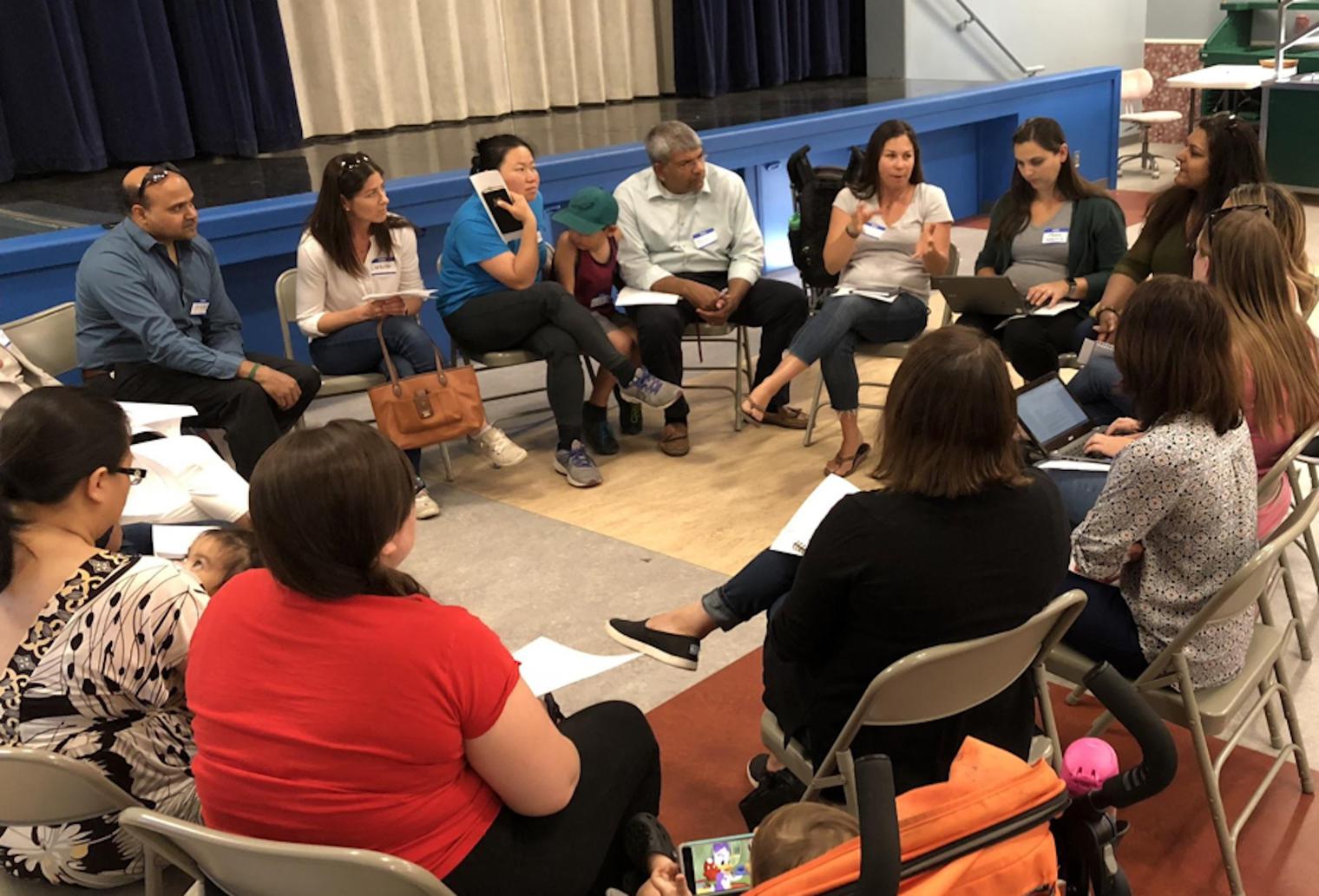 adults sitting in a circle engaged in discussion