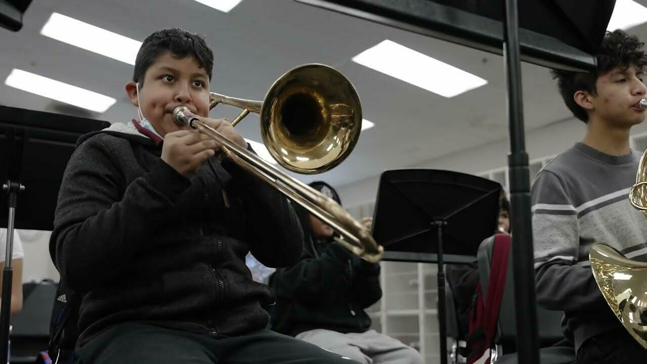 middle school boy playing a trombone