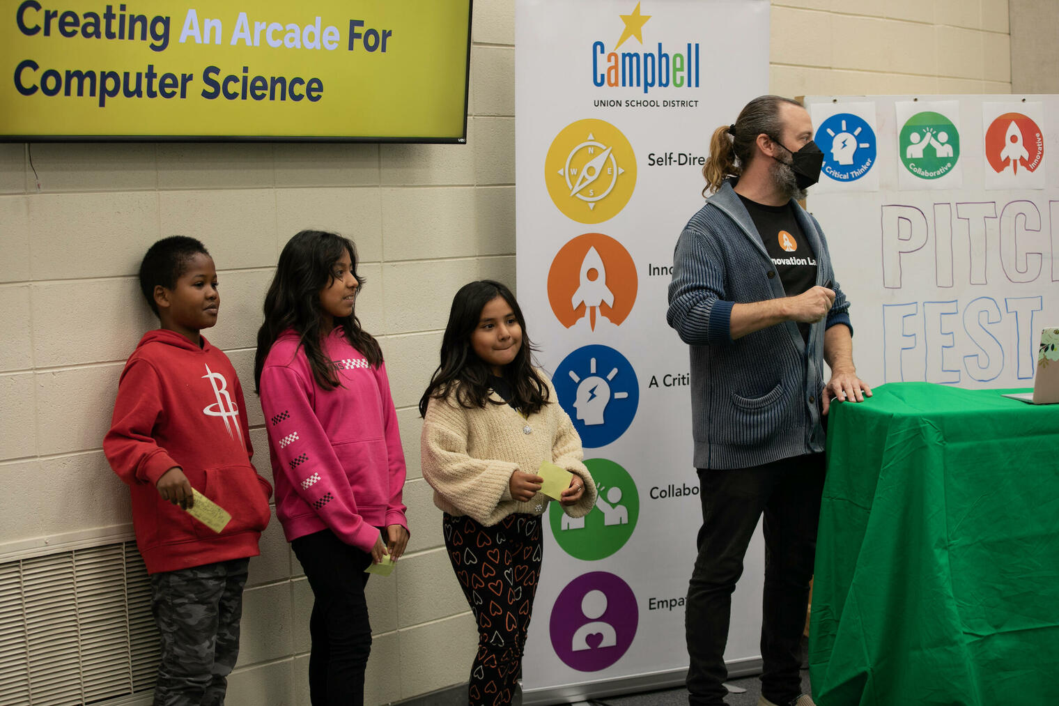 students and teacher standing and presenting to audience