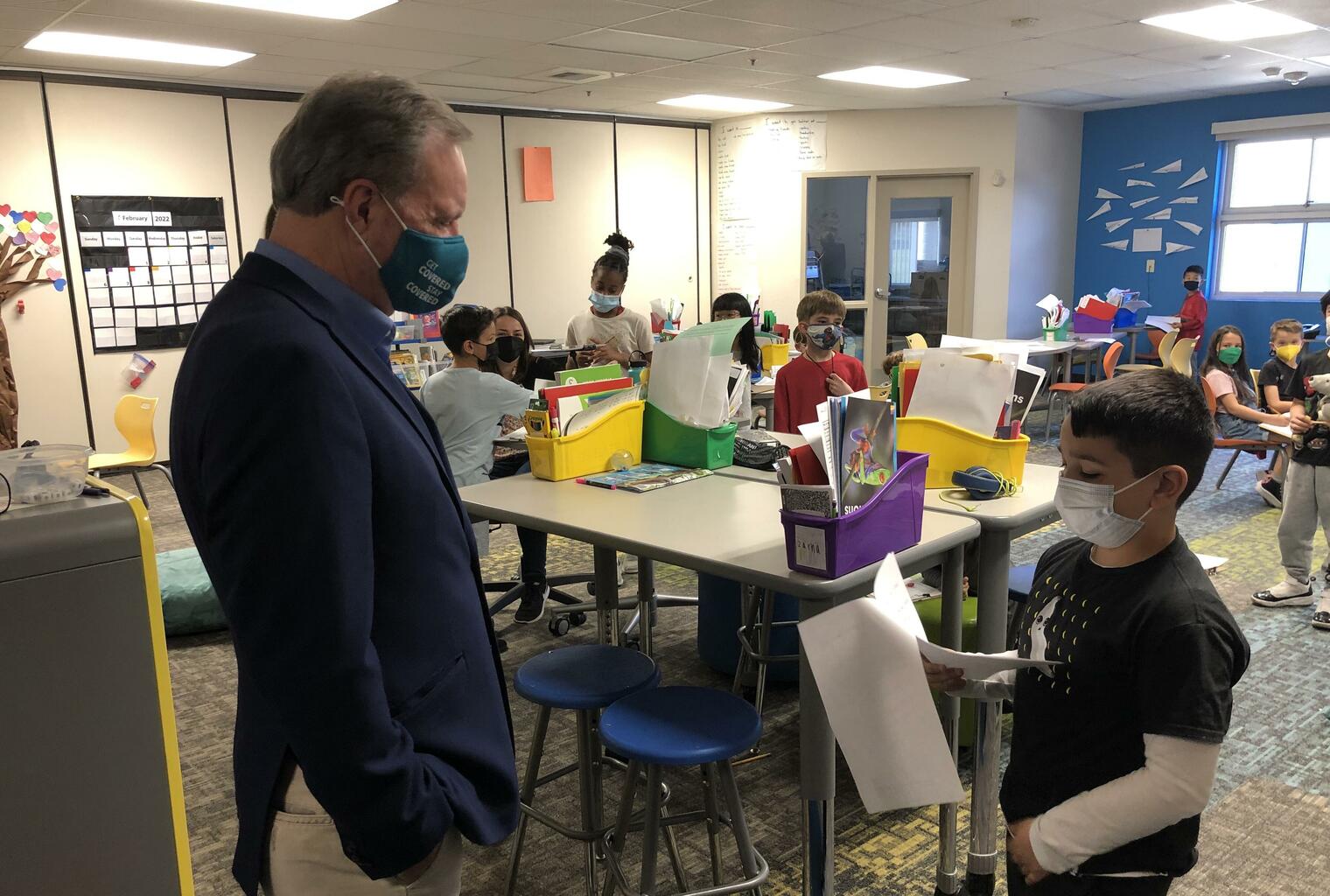 Senator listens as boy reads a letter to him