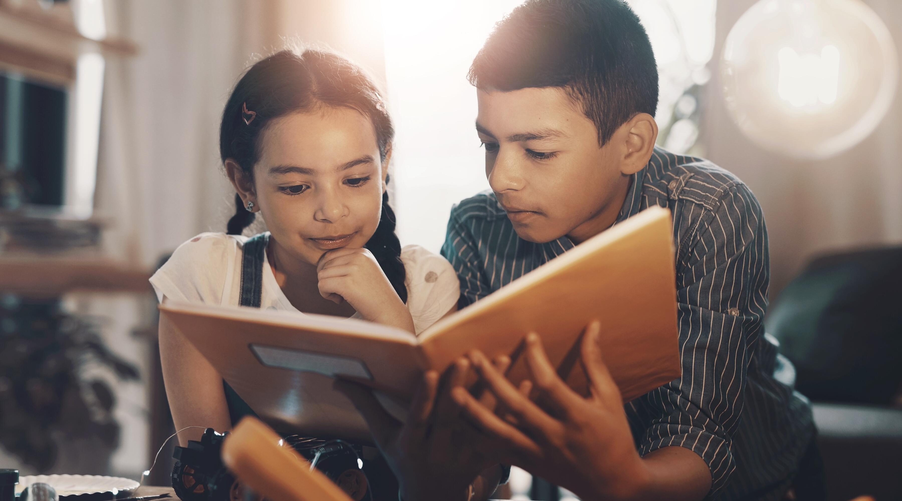 brother and sister reading together at home