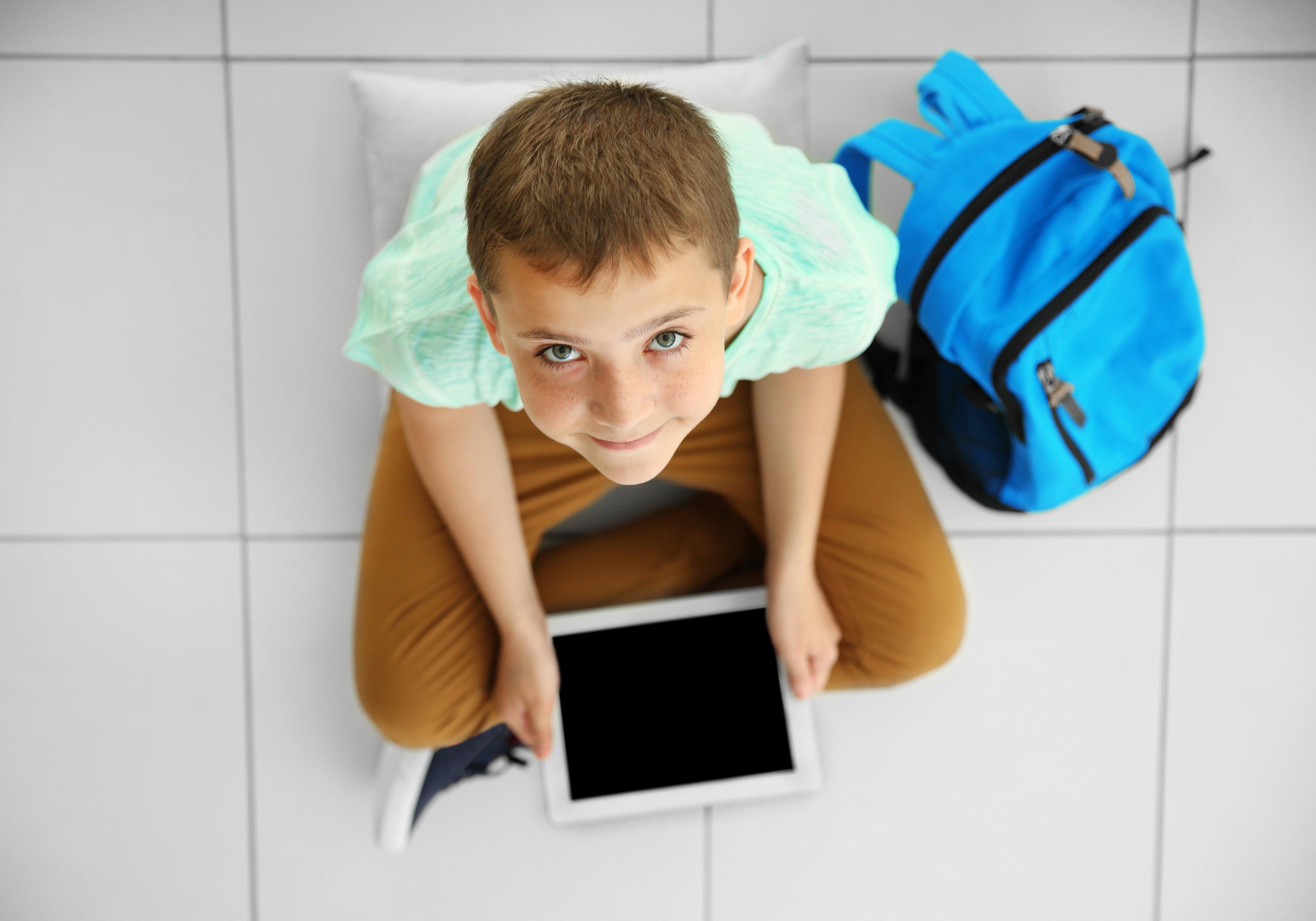 boyon floor with digital tablet smiling