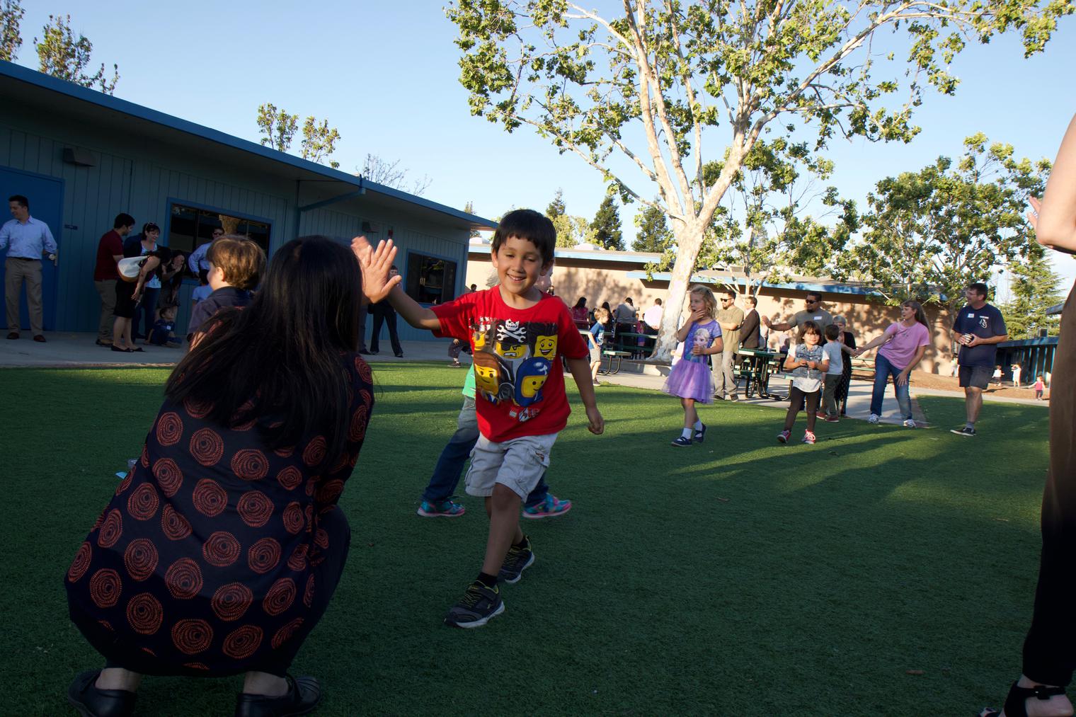 a young CSI student gets a high five from one of the parents