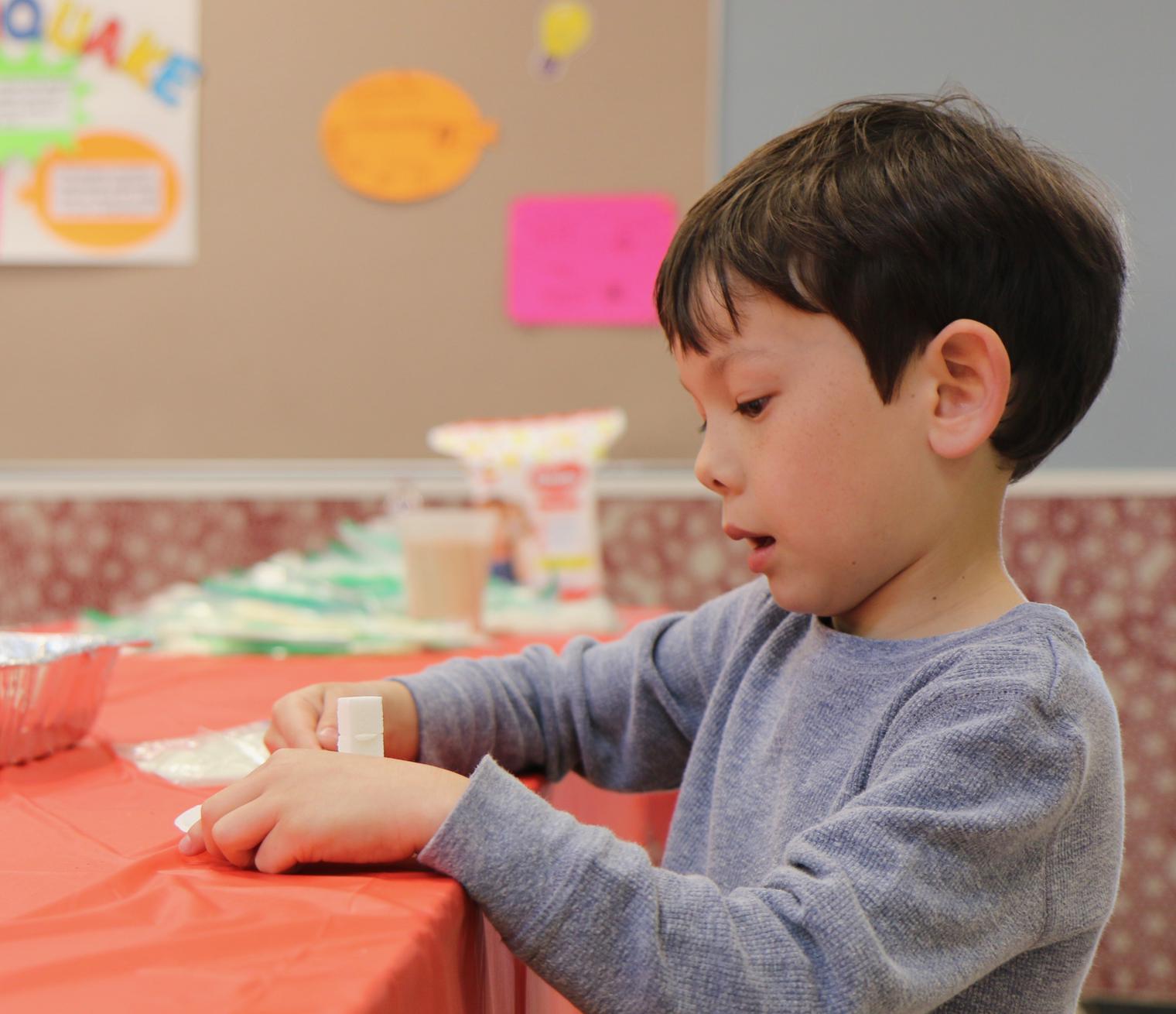 boy at table working with tape